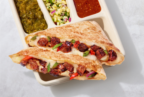 A Smoked Brisket Quesadilla with hand-chopped Smoked Brisket, melted monterey jack cheese, and fresh fajita veggies with a side of tomatillo green chili salsa, roasted corn salsa, and tomatillo red chili salsa.